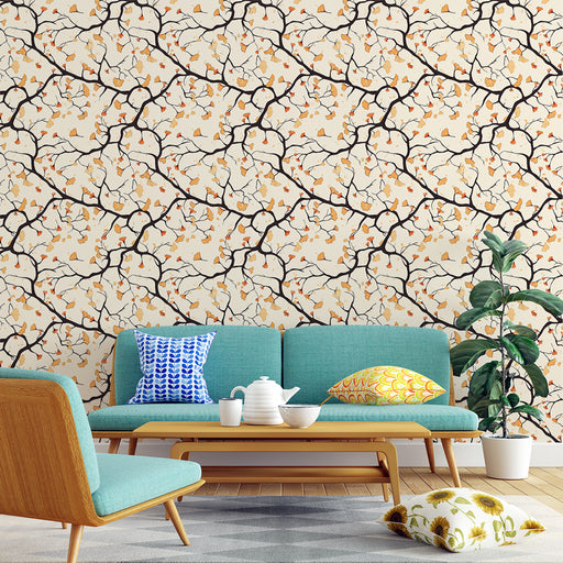 Une pièce de vie moderne avec un papier peint illustrant des branches noires ornées de fleurs blanches et de feuilles dorées, créant une ambiance chaleureuse et accueillante.