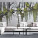 Un salon moderne avec un papier peint illustrant des arbres stylisés et des feuillages verts sur fond clair, créant une atmosphère apaisante et naturelle.