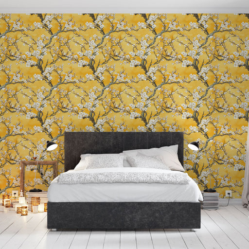 Une chambre moderne avec un papier peint floral jaune vif illustrant des branches d'arbres en fleurs, créant une ambiance chaleureuse et joyeuse.