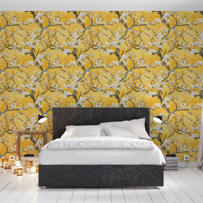 Une chambre moderne avec un papier peint floral jaune vif illustrant des branches d'arbres en fleurs, créant une ambiance chaleureuse et joyeuse.
