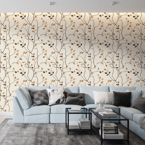 Un salon moderne avec un papier peint aux motifs de branches délicates et feuilles dorées sur fond crème, créant une ambiance chaleureuse et naturelle.