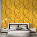 Une chambre moderne avec un papier peint jaune vif illustrant des branches nues et des lanternes suspendues, créant une ambiance chaleureuse et accueillante.
