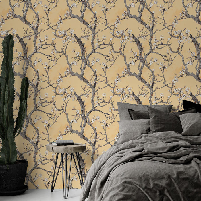 Une chambre élégante avec un papier peint floral aux branches grises et fleurs blanches sur fond jaune, créant une atmosphère chaleureuse et apaisante.