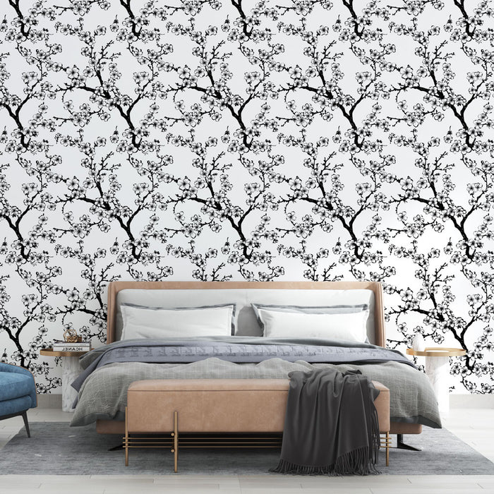 Une chambre moderne avec un papier peint floral noir et blanc représentant des branches fleuries, créant une atmosphère élégante et apaisante.