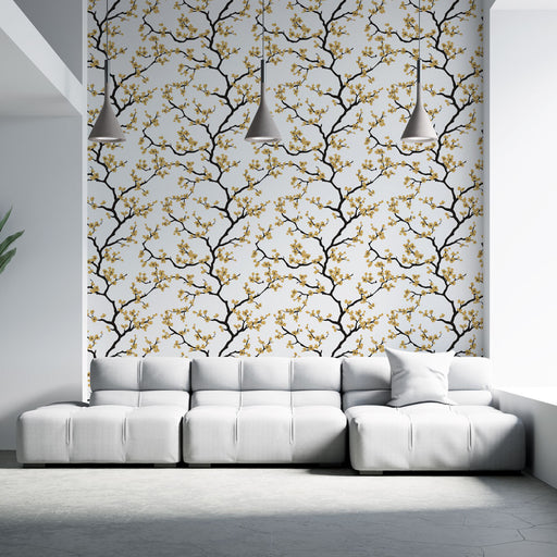 Un salon contemporain avec un papier peint floral aux branches noires et fleurs dorées sur fond blanc, créant une atmosphère élégante et chaleureuse.