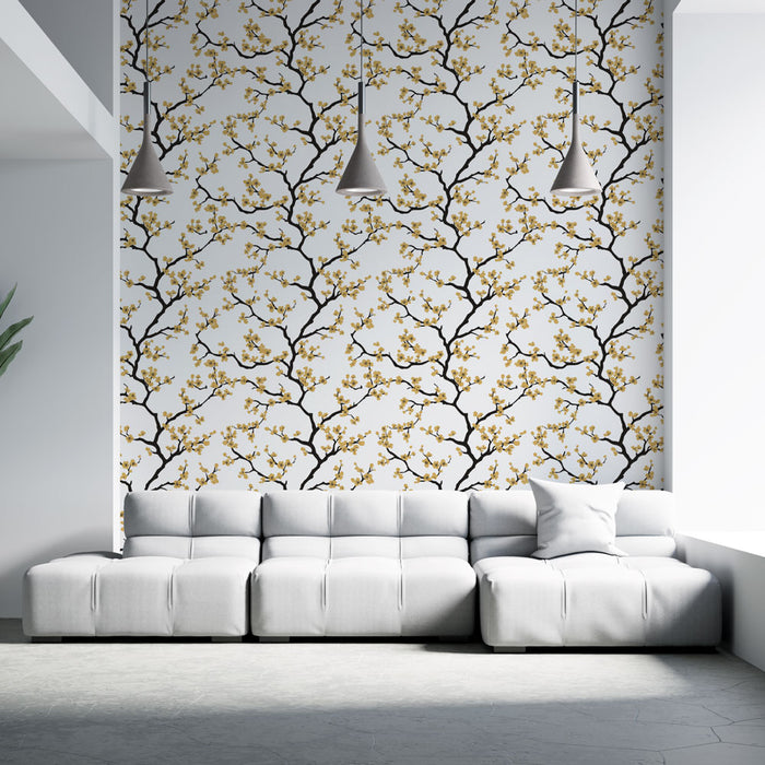 Un salon contemporain avec un papier peint floral aux branches noires et fleurs dorées sur fond blanc, créant une atmosphère élégante et chaleureuse.