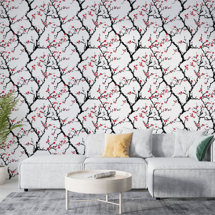 Un salon moderne avec un papier peint représentant des branches noires ornées de fleurs rouges sur fond blanc, créant une ambiance élégante et vivifiante.