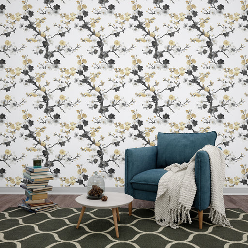 Une pièce cosy avec un papier peint floral aux motifs de branches noires et fleurs jaunes sur fond blanc, créant une ambiance douce et apaisante.
