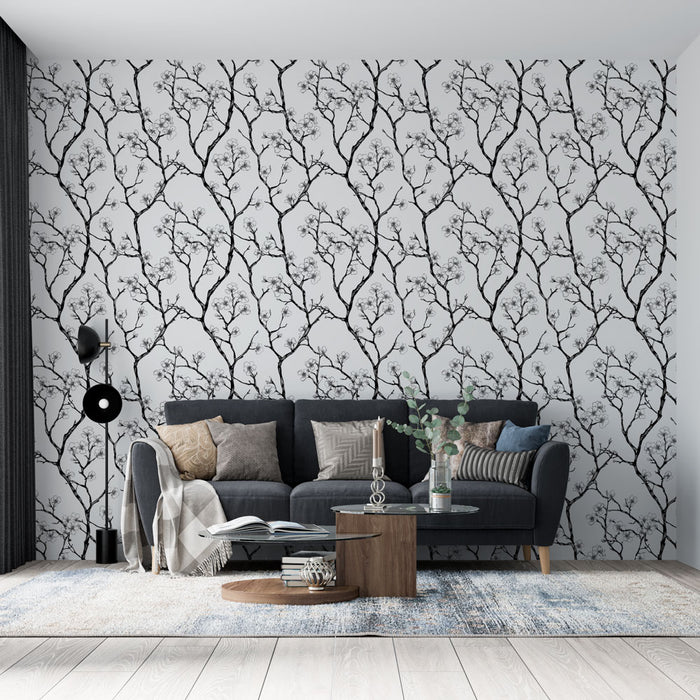 Un salon moderne avec un papier peint aux motifs de branches noires sur fond clair, créant une ambiance élégante et apaisante.