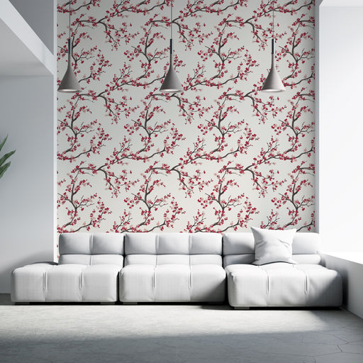 Un salon moderne avec un papier peint floral aux motifs de branches et fleurs rouges sur fond clair, créant une ambiance chaleureuse et accueillante.