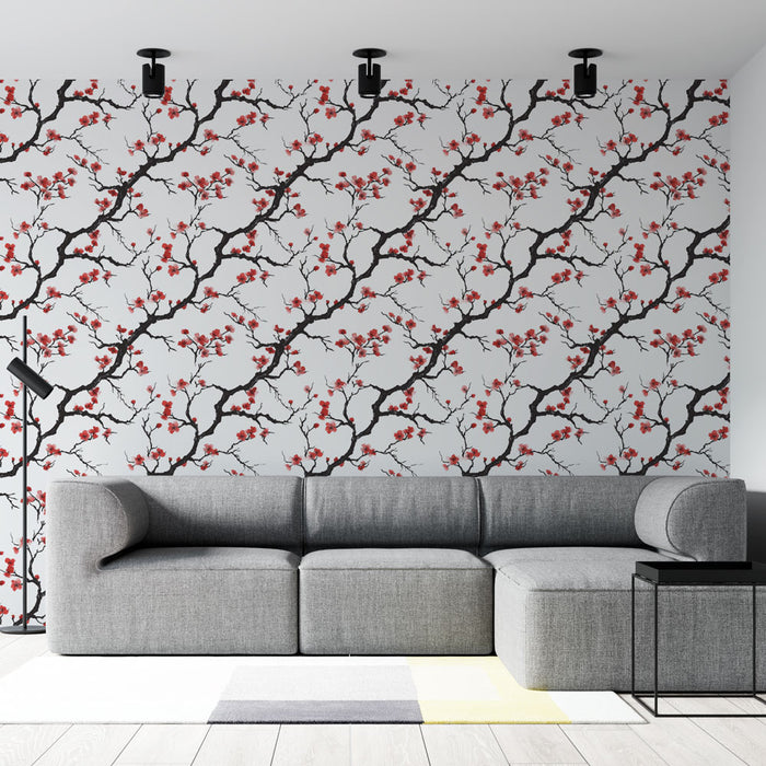 Un salon moderne avec un papier peint floral représentant des branches noires ornées de fleurs rouges sur fond clair, créant une ambiance élégante et dynamique.