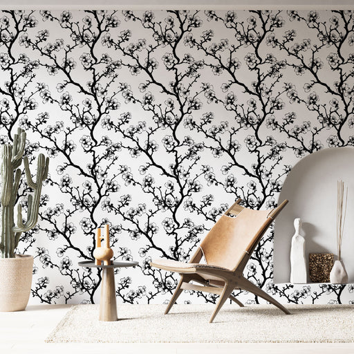 Une pièce moderne avec un papier peint noir et blanc représentant des branches fleuries, créant une atmosphère élégante et artistique.