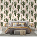 Une chambre moderne avec un papier peint représentant des cactus verts sur un fond rose pastel, créant une ambiance chaleureuse et accueillante.