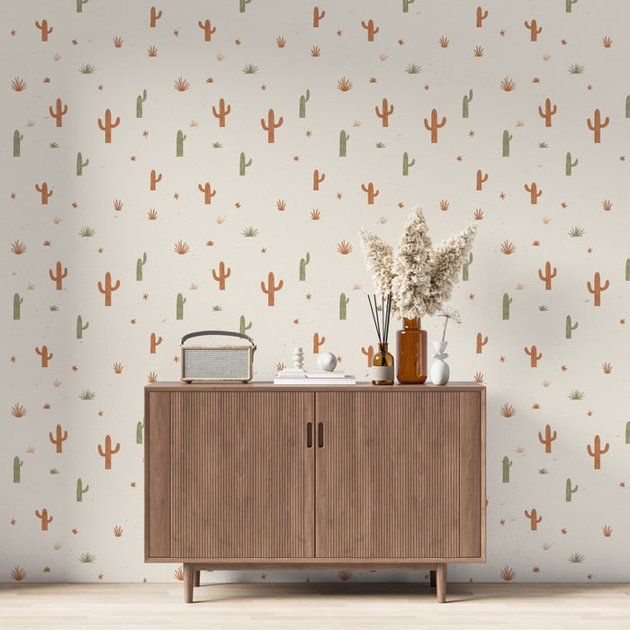Une salle de séjour avec un papier peint aux motifs de cactus colorés dans des tons terracotta et vert sur fond crème, créant une ambiance chaleureuse et naturelle.