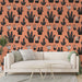 Un salon moderne avec un papier peint aux motifs de cactus noirs et blancs sur fond corail, créant une ambiance chaleureuse et ludique.