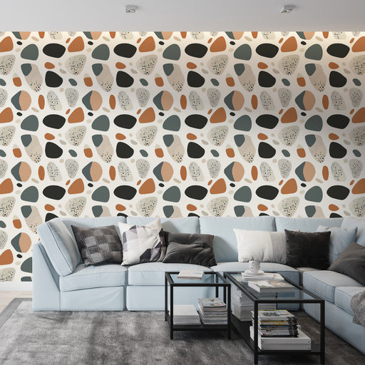 Un salon contemporain avec un papier peint abstrait aux formes organiques dans des teintes de bleu, terracotta et noir, créant une ambiance dynamique et chaleureuse.