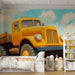 Papier peint vintage avec camion jaune sur chemin de campagne ensoleillé pour chambre d'enfant.