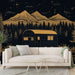 Un salon moderne avec un papier peint représentant un paysage nocturne de montagnes dorées et un camping-car sur fond noir, créant une ambiance chaleureuse et aventureuse.