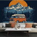 Une pièce de vie moderne avec un papier peint illustrant un van orange sur fond de montagnes majestueuses et d'un ciel orangé, créant une ambiance chaleureuse et aventureuse.