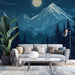 Un salon moderne avec un papier peint représentant des montagnes majestueuses sous un ciel nocturne étoilé, créant une atmosphère apaisante et contemplative.