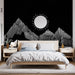 Une chambre moderne avec un papier peint noir illustrant des montagnes stylisées en blanc et un soleil minimaliste, créant une ambiance graphique et apaisante.