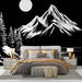 Une chambre moderne avec un papier peint représentant des montagnes blanches stylisées sur fond noir, créant une ambiance à la fois dramatique et apaisante.