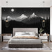 Une chambre moderne avec un papier peint représentant des montagnes en noir et blanc sous un ciel étoilé, créant une atmosphère apaisante et contemplative.