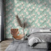 Une chambre moderne avec un papier peint floral aux motifs de fleurs roses sur fond vert menthe, créant une atmosphère douce et apaisante.
