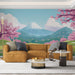 Un salon contemporain avec un papier peint représentant un paysage montagneux apaisant, orné de cerisiers en fleurs et d'un ciel bleu clair.