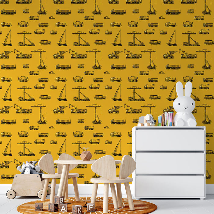 Une chambre d'enfant avec un papier peint jaune vif illustré de dessins de camions et de grues en noir, créant une ambiance ludique et dynamique.