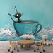 Une chambre d'enfant avec un papier peint ludique représentant un chat noir dans une tasse turquoise naviguant sur des vagues, créant une ambiance joyeuse et imaginative.