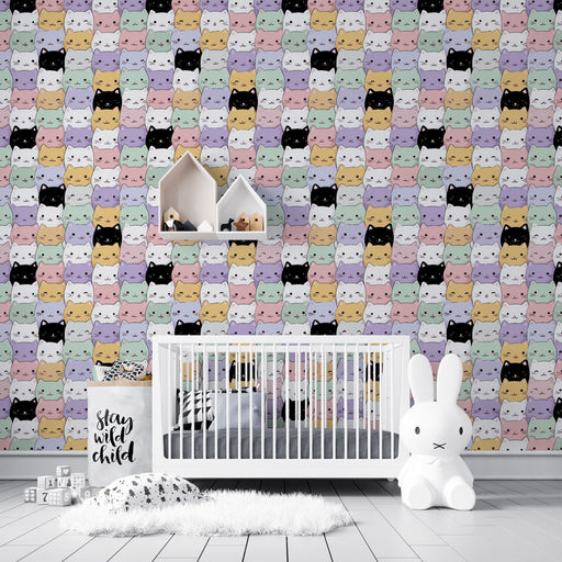 Une chambre d'enfant avec un papier peint ludique représentant des visages de chats colorés sur fond pastel, créant une atmosphère joyeuse et accueillante.