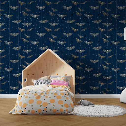 Une chambre moderne avec un papier peint bleu nuit orné de chauves-souris stylisées et d'étoiles dorées, créant une ambiance mystérieuse et ludique.
