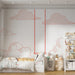 Une chambre enfantine avec un papier peint illustrant des nuages stylisés en rouge sur fond blanc, créant une atmosphère ludique et aérienne.