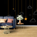 Un salon moderne avec un papier peint noir illustré de nuages et d'étoiles blanches et dorées, créant une atmosphère ludique et apaisante.