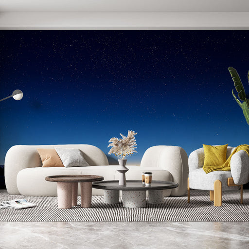 Un salon moderne avec un papier peint représentant un ciel étoilé dégradé de bleu nuit, créant une ambiance sereine et contemplative.