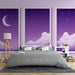 Une chambre moderne avec un papier peint dégradé violet illustrant des nuages et un croissant de lune, créant une atmosphère rêveuse et apaisante.