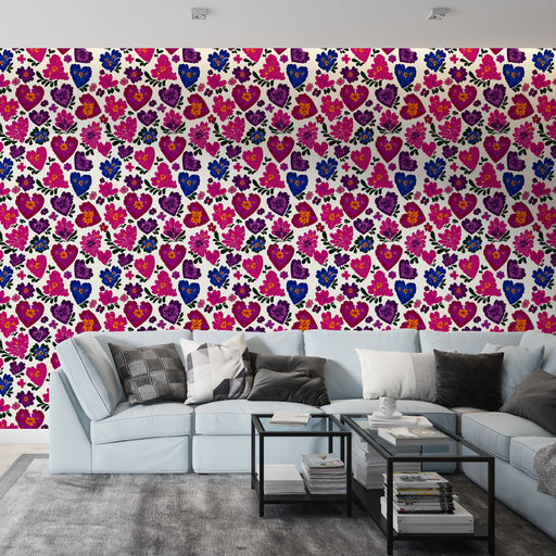 Un salon contemporain avec un papier peint coloré aux motifs de cœurs et de fleurs dans des tons vifs de rose, violet et bleu, créant une ambiance joyeuse et dynamique.