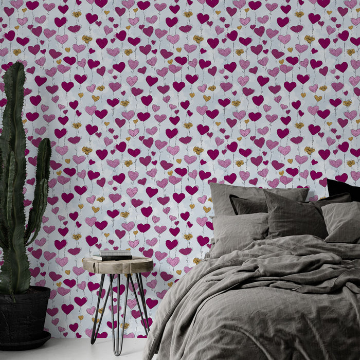 Une chambre moderne avec un papier peint ludique aux motifs de cœurs roses et dorés sur fond clair, créant une atmosphère romantique et joyeuse.