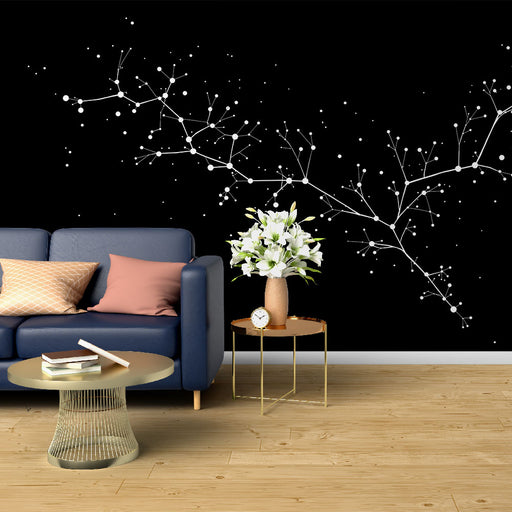 Un salon contemporain avec un papier peint noir orné de motifs étoilés et de branches blanches, créant une atmosphère cosmique et apaisante.
