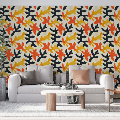 Un salon moderne avec un papier peint aux motifs organiques en rouge, jaune, noir et beige, créant une ambiance dynamique et chaleureuse.