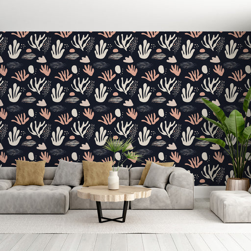 Un salon moderne avec un papier peint aux motifs abstraits de coraux blancs et roses sur fond noir, créant une atmosphère dynamique et chaleureuse.