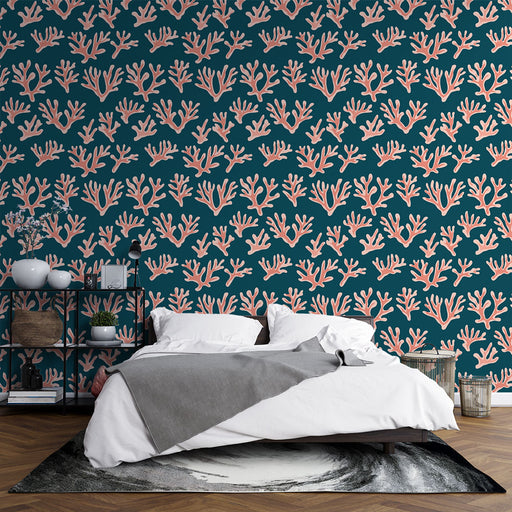 Une chambre moderne avec un papier peint marin bleu profond orné de motifs coralliens en rose, créant une atmosphère apaisante et inspirante.