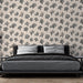 Une chambre moderne avec un papier peint représentant des motifs de coraux noirs sur fond beige, créant une ambiance apaisante et naturelle.