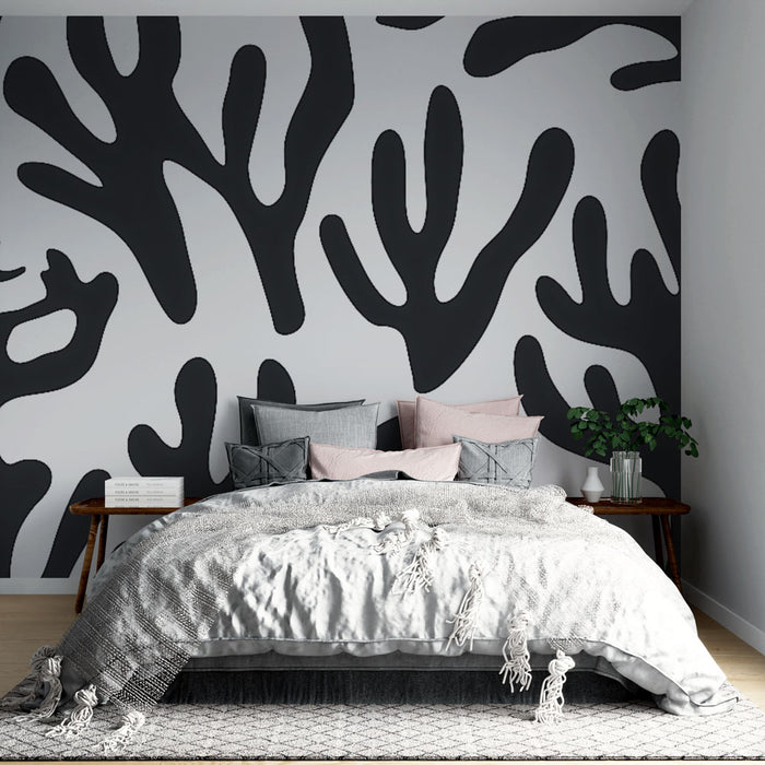 Une chambre moderne avec un papier peint abstrait noir représentant des formes organiques sur fond clair, créant une ambiance artistique et contemporaine.