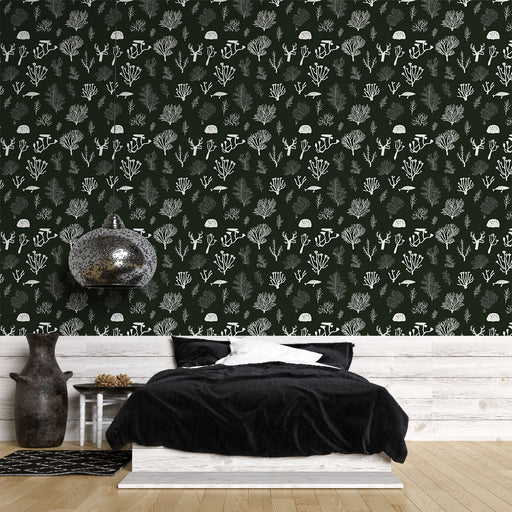 Une chambre moderne avec un papier peint botanique sur fond vert foncé, illustrant des motifs de coraux et de plantes blanches, créant une atmosphère apaisante et naturelle.