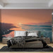 Une chambre moderne avec un papier peint représentant un paysage côtier au coucher de soleil, évoquant une atmosphère paisible et relaxante.