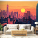 Un salon contemporain avec un papier peint représentant une vue urbaine stylisée au coucher de soleil, mêlant des teintes chaudes et des silhouettes de gratte-ciel.