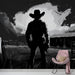 Un salon contemporain avec un papier peint monochrome représentant un cowboy en silhouette, créant une atmosphère dramatique et mystérieuse.