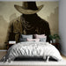 Une chambre moderne avec un papier peint représentant une silhouette mystérieuse de cowboy sur fond beige, créant une ambiance à la fois audacieuse et intrigante.
